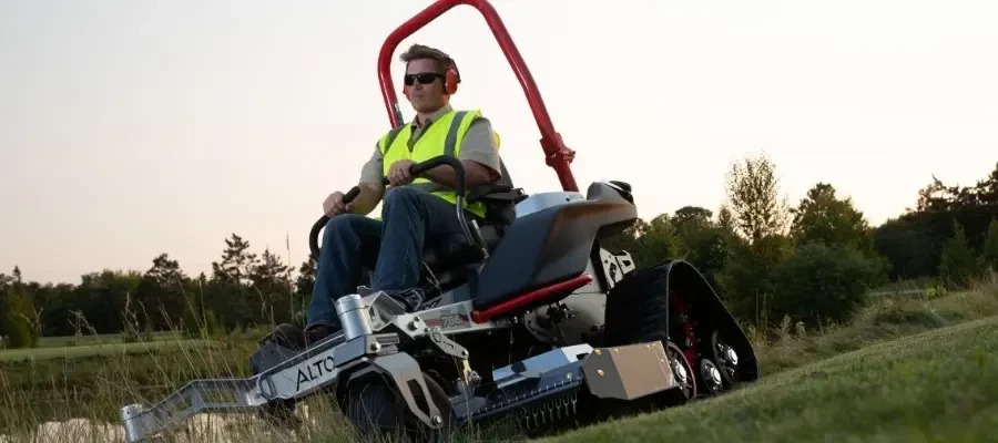 Man operating Altoz 766 zero-turn mower on a hillside